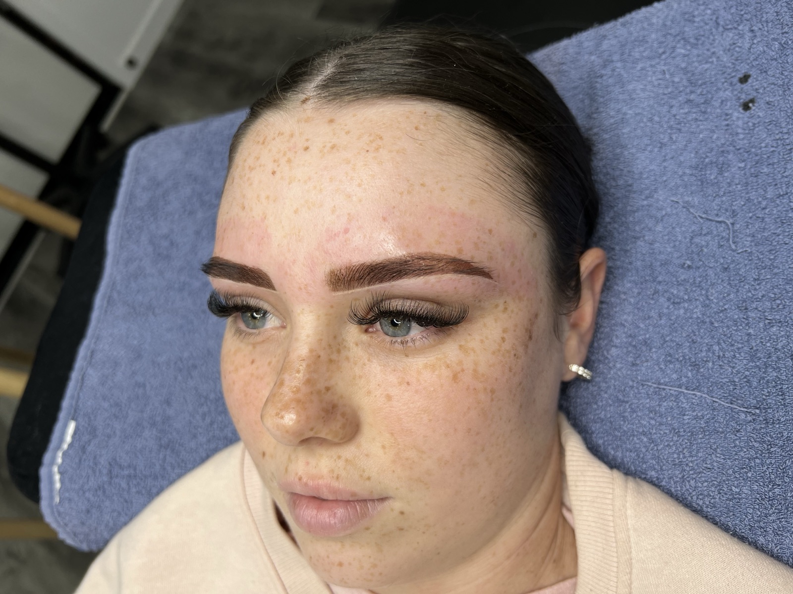 Healed cosmetic brow tattoo result — defined, natural-looking ombré brows on a freckled complexion